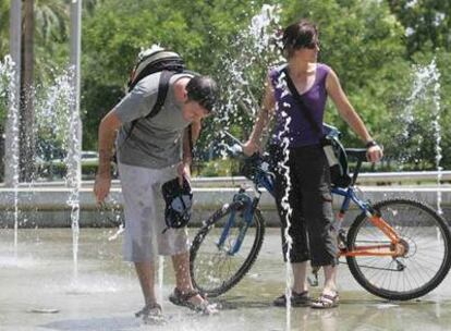 Unos jóvenes se refrescan en una fuente en Córdoba.