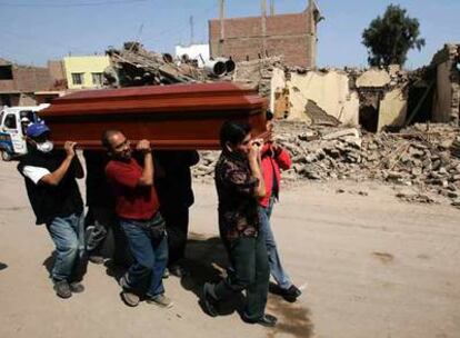Habitantes de Pisco transportan en un ataúd el cadáver de una de las víctimas del terremoto.