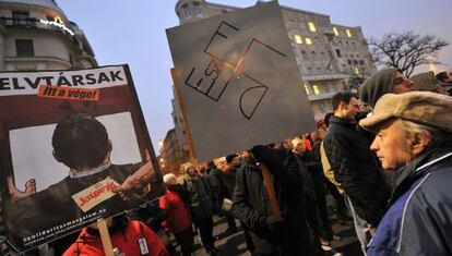 Manifestantes antigubernamentales portan una pancarta con las siglas de l partido oficial FIDESZ formando una esvástica, en una protesta el pasado 23 de diciembre.