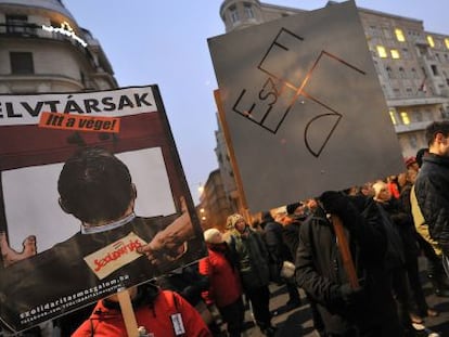 Manifestantes antigubernamentales portan una pancarta con las siglas de l partido oficial FIDESZ formando una esv&aacute;stica, en una protesta el pasado 23 de diciembre.