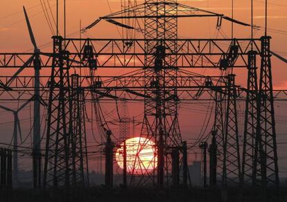 Una puesta de sol junto al tendido el&eacute;ctrico y unos molinos de viento.