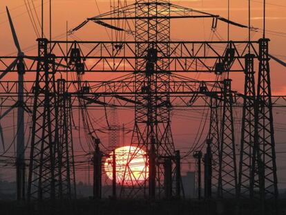 Una puesta de sol junto al tendido el&eacute;ctrico y unos molinos de viento.