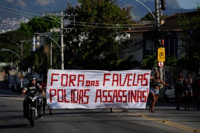 Luego de la redada, habitantes de la favela Alemão caminaron en protesta portando una manta con la leyenda "Fuera de las favelas, policías asesinas", este jueves.