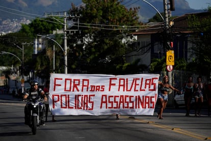 Luego de la redada, habitantes de la favela Alemão caminaron en protesta portando una manta con la leyenda "Fuera de las favelas, policías asesinas", este jueves.