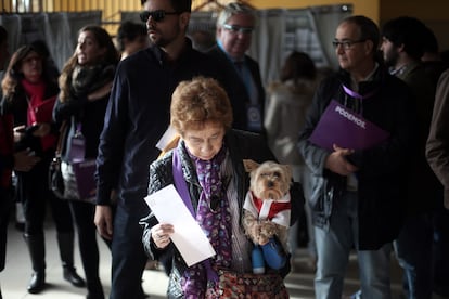 Una señora junto a su perro espera su turno para votar en un colegio electoral de Madrid.