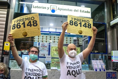 Empleados del establecimiento que vendió el primer premio de la Lotería de Navidad (86148) en la estación de Atocha de Madrid.