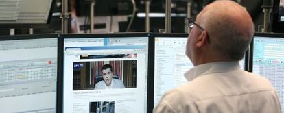 Un operador de mercat, a la Borsa de Frankfurt, davant una pantalla que mostra Alexis Tsipras.