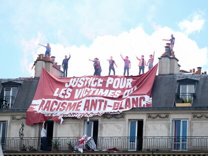 Activistas de extrema derecha deslizan una pancarta que pide justicia para las "víctimas del racismo anti-blanco" en una azotea de París el 13 de junio de 2020.