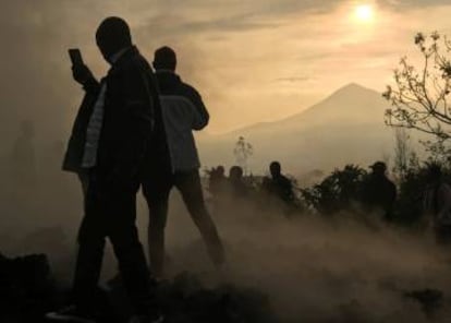 Un vecino usa su teléfono móvil para tomar fotografías de las casas destruidas por la lava, que aún siguen humeantes, cerca de Goma (República del Congo), este domingo.