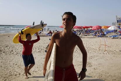 Niños que estaban en clases de surf miran al cielo en el momento en que un cohete lanzado por las milicias palestinas es interceptado por el sistema antimisiles israelí, Cúpula de Hierro.