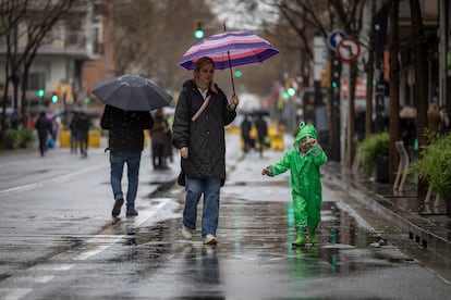 Vecinos caminan por la carretera de Sants durante la jornada de lluvias en plena sequía, este sábado.