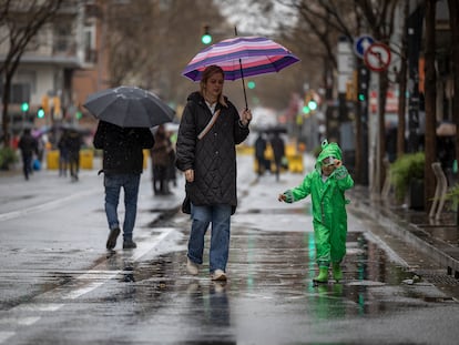 Vecinos caminan por la carretera de Sants durante la jornada de lluvias en plena sequía, este sábado.