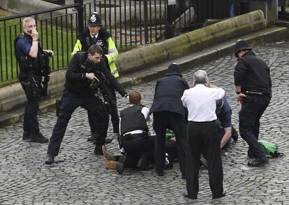 Un policía apunta al sospechoso, frente al Parlamento.