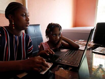 Kesieana Onoge y su hija Naomi, de seis años, siguen un programa de aprendizaje en internet diseñado por la escuela de la niña durante el confinamiento impuesto por el Gobierno para contener la pandemia de covid-19. En Lagos, Nigeria, 23 de abril de 2020.