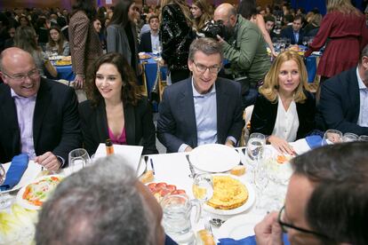 El presidente nacional del PP, Alberto Núñez Feijóo (segundo por la derecha) y la presidenta de la Comunidad de Madrid, Isabel Díaz Ayuso (segunda por la izquierda), durante la cena de Navidad del PP madrileño, en el Pabellón Deportivo Municipal Antela Parada de Alcobendas.
