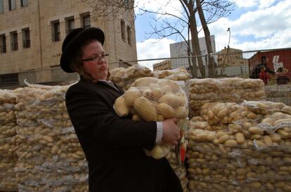 Un niño judío ultra-ortodoxo participa en la distribución de patatas a las personas necesitadas durante los preparativos de la Pesaj, que conmemora el éxodo de los israelitas de la esclavitud en Egipto, en Jerusalén, Israel.