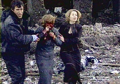 Una mujer herida, ayudada por dos compatriotas, sale del lugar del atentado ayer, en una imagen tomada de la televisión.