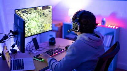 Un chico jugando a un videojuego en su habitación.