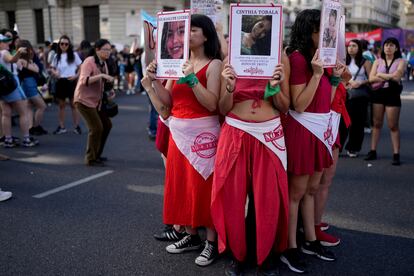 Manifestantes sostienen fotos de víctimas de tráfico de personas durante la marcha del 25 de noviembre en Buenos Aires, Argentina.