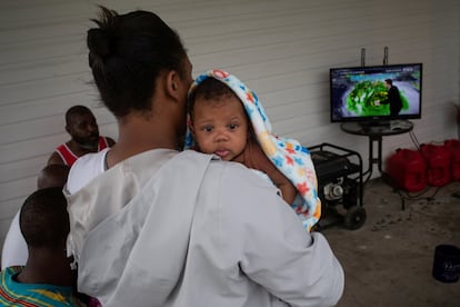 LaKeisha Verdin sostiene a su hijo de tres meses mientras ella y su familia ven el canal local de noticias sobre las actualizaciones del huracán Ida horas antes de su llegada a tierra, en Houma, Louisiana.