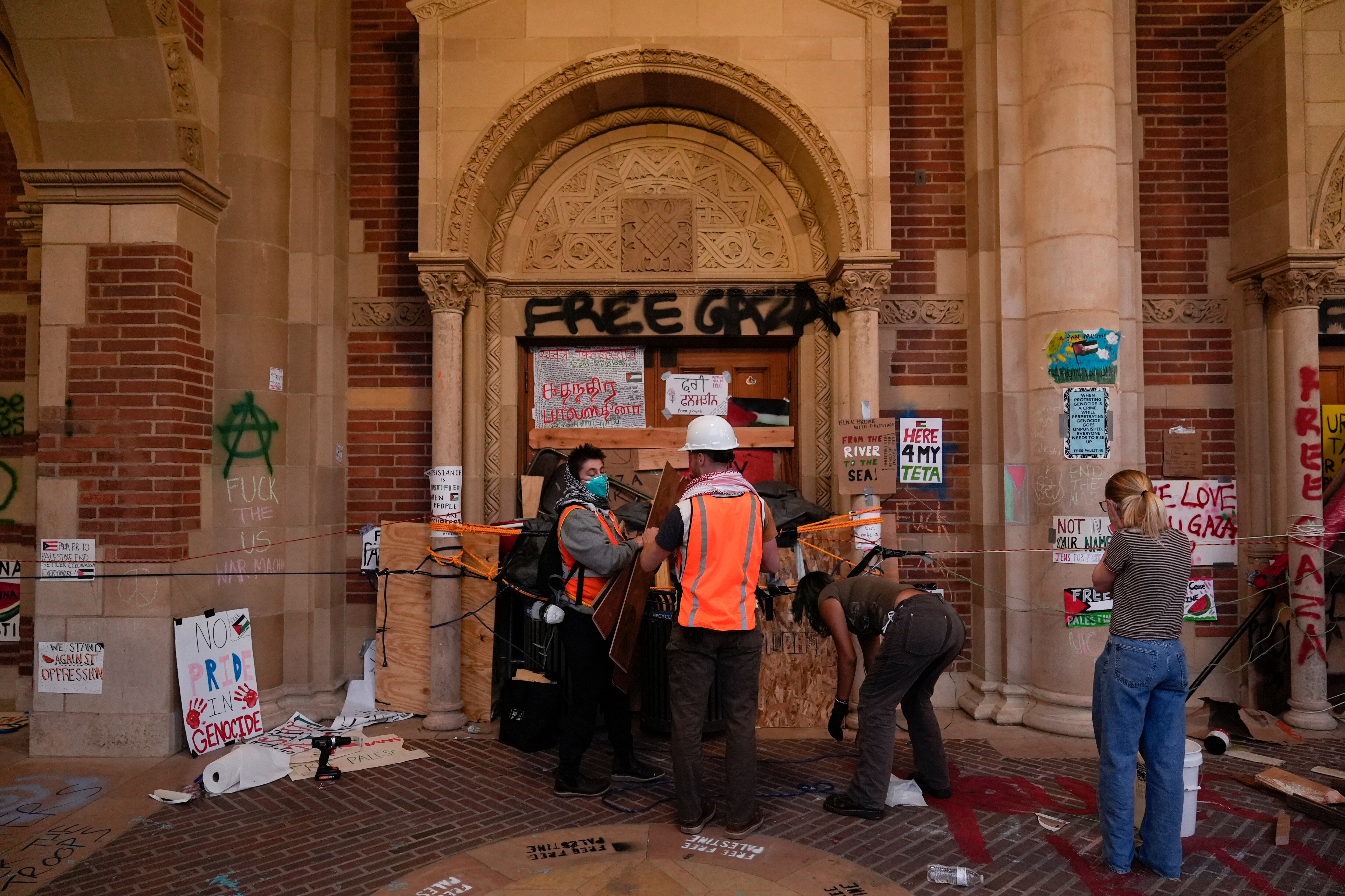 Unos estudiantes construyen una barricada en las puertas de un edificio de la universidad, antes de la entrada de los policías al campamento.