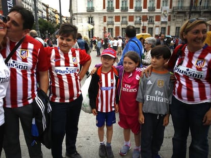 Un grupo de seguidores del Atlético junto a unos aficionados del Real Madrid, en la Puerta del Sol.