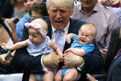 Donald Trump sostiene a dos bebés, durante un acto de campaña en Colorado Springs el 29 de julio de 2016.