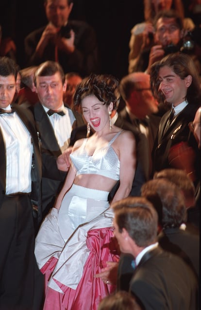 Madonna en 1991 revolucionó la alfombra roja del Festival de Cannes durante el estreno de su documental 'In Bed with Madonna'. Madonna lució un conjunto diseñado por Jean Paul Gaultier, compuesto por un corsé cónico negro y una minifalda a juego. El diseño recordaba al icónico “look” de su su gira Blond Ambition Tour en 1990,y estaba inspirado en los sujetadores "bullet bra" de los años 40. Aquella foto dejó una huella imborrable en la intersección entre la moda, la música y el cine.