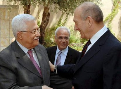 Ehud Olmert (derecha) saluda a Mahmud Abbas ante el jefe negociador palestino, Saeb Erekat, en Jerusalén.