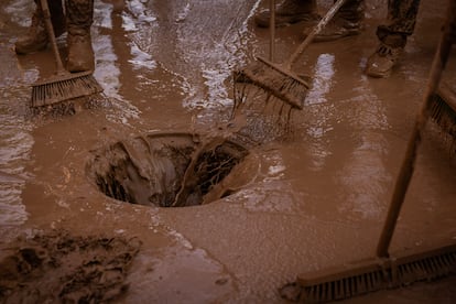 Un grupo de voluntarios trabaja para retirar el lodo que inunda las calles de Paiporta, viernes 1 de noviembre de 2024.