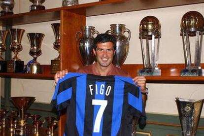 Luis Figo posa con una camiseta de su nuevo equipo, el Inter de Milán, tras firmar un contrato de dos años