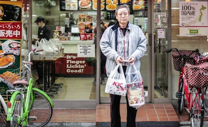 Um homem sai de um KFC em Tóquio (Japão) com seu menu natalino.