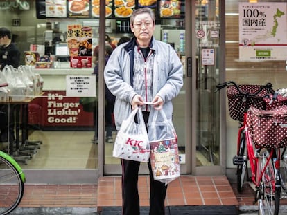 Un hombre sale de un KFC en Tokio (Japón) con su menú navideño.