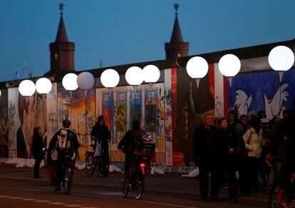 Grupo de pedestres caminha pelo muro no trecho do East Side Gallery, em Berlim (Alemanha), em 8 de novembro de 2014.