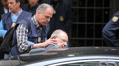 Un policia introdueix Rato en un cotxe després de la seva detenció el 2015.