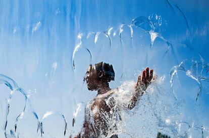 Un niño pasa por una cortina de agua en el Yards Park en Washington D.C (Estados Unidos).