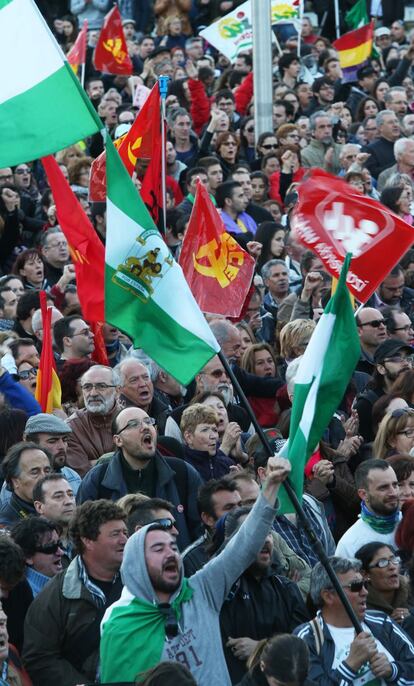 Un grupo de manifestantes gritan y ondean banderas durante la marcha que ha llenado las calles de Madrid.