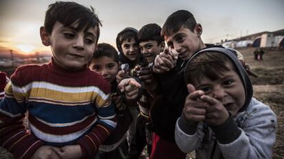Niños yazidíes juegan con pistolas simuladas en el campo de refugiados de Essian.