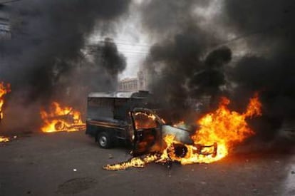 Vehículos policiales incendiados por los peregrinos chiíes tras el atentado, en Karachi.
