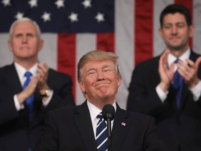 O presidente Trump sorri na presença do seu vice, Mike Pence, e do presidente da Câmara de Deputados, Paul Ryan.