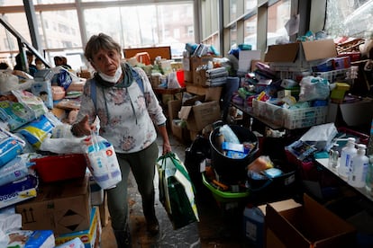 Una mujer recoge bienes de primera necesida, en un centro de distribución, este lunes en Paiporta.