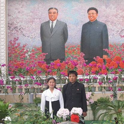 Una pareja se fotografía ante el retrato de Kim Il Sung (izquierda) y Kim Jong Il.