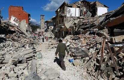 Un hombre camina entre casas derrumbadas después de un terremoto en Pescara del Tronto (Italia).
