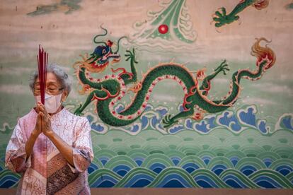 Una anciana reza durante la celebración en Bali (Indonesia). Los países del sudeste asiático llevan días preparándose para dar la bienvenida al Año Nuevo chino, a pesar de los estrictos protocolos de salud debido a la pandemia de la covid-19.