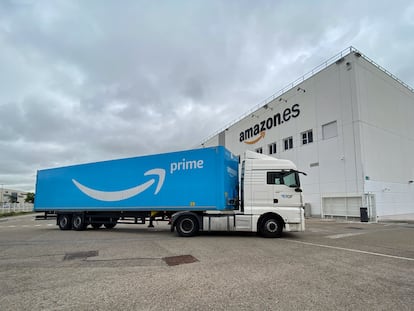 Camión de transporte de Amazon frente a una nave de la compañía en España.