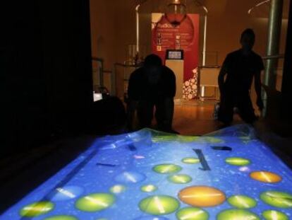 Dos hombres ultiman detalles de la exposici&oacute;n Mol&eacute;culas de Vida en el Museo Nacional de Ciencias.
 