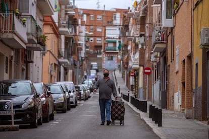 Un hombre con carrito de la compra baja por una calle del barrio Zofío, una de las 37 zonas confinadas en Madrid.