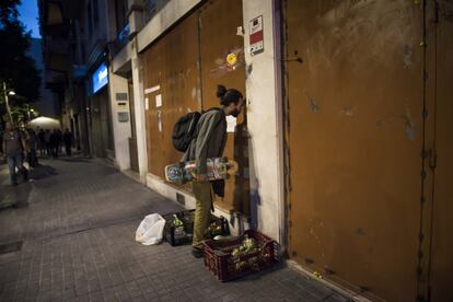 Un curioso mira en el interior de la sede del Banc Expropiat.