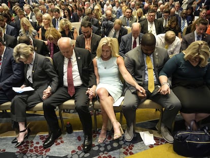 Los representantes Louie Gohmert y Marjorie Taylor Greene, entre otros seguidores de Trump, rezan en la convención de America First Agenda, el martes en Washington.