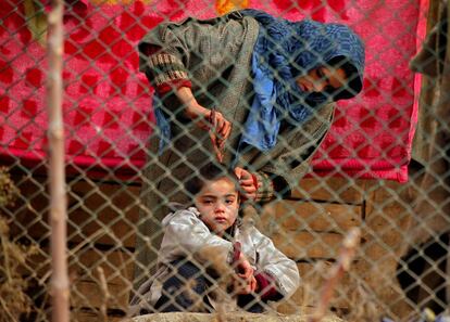 Una niña llora mientras su madre la peina el pelo fuera de su casa en Srinagar (India), el 22 de diciembre de 2017. 